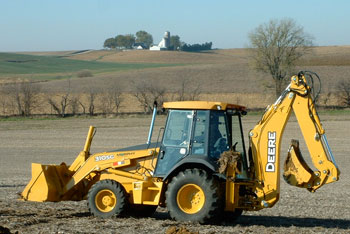 A John Deere backhoe in a field.